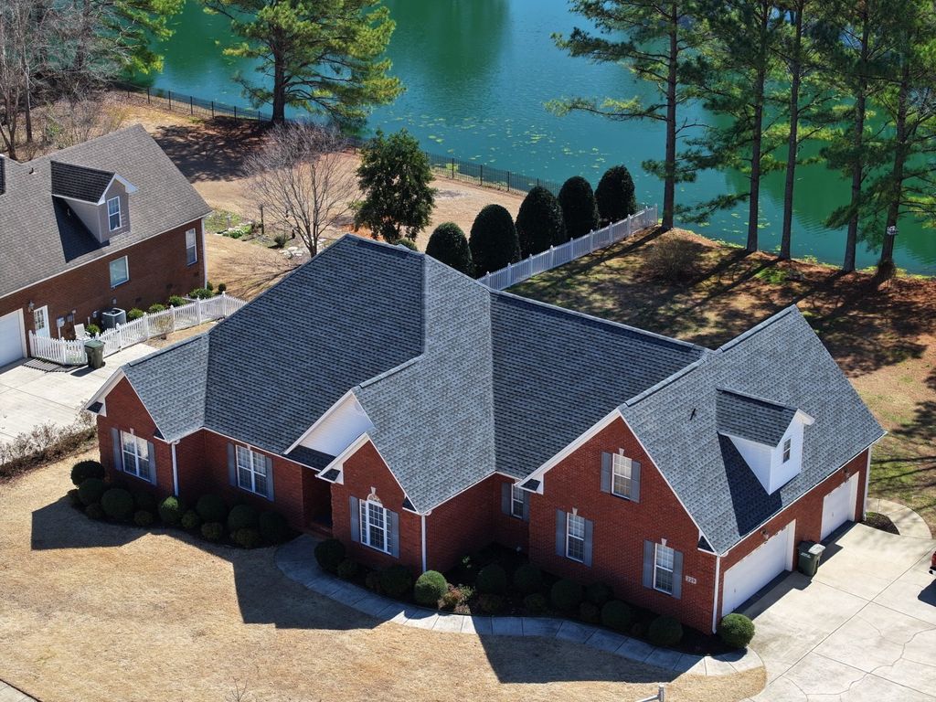 Drone photograph of a completed architectural shingle roof on a lakefront brick home